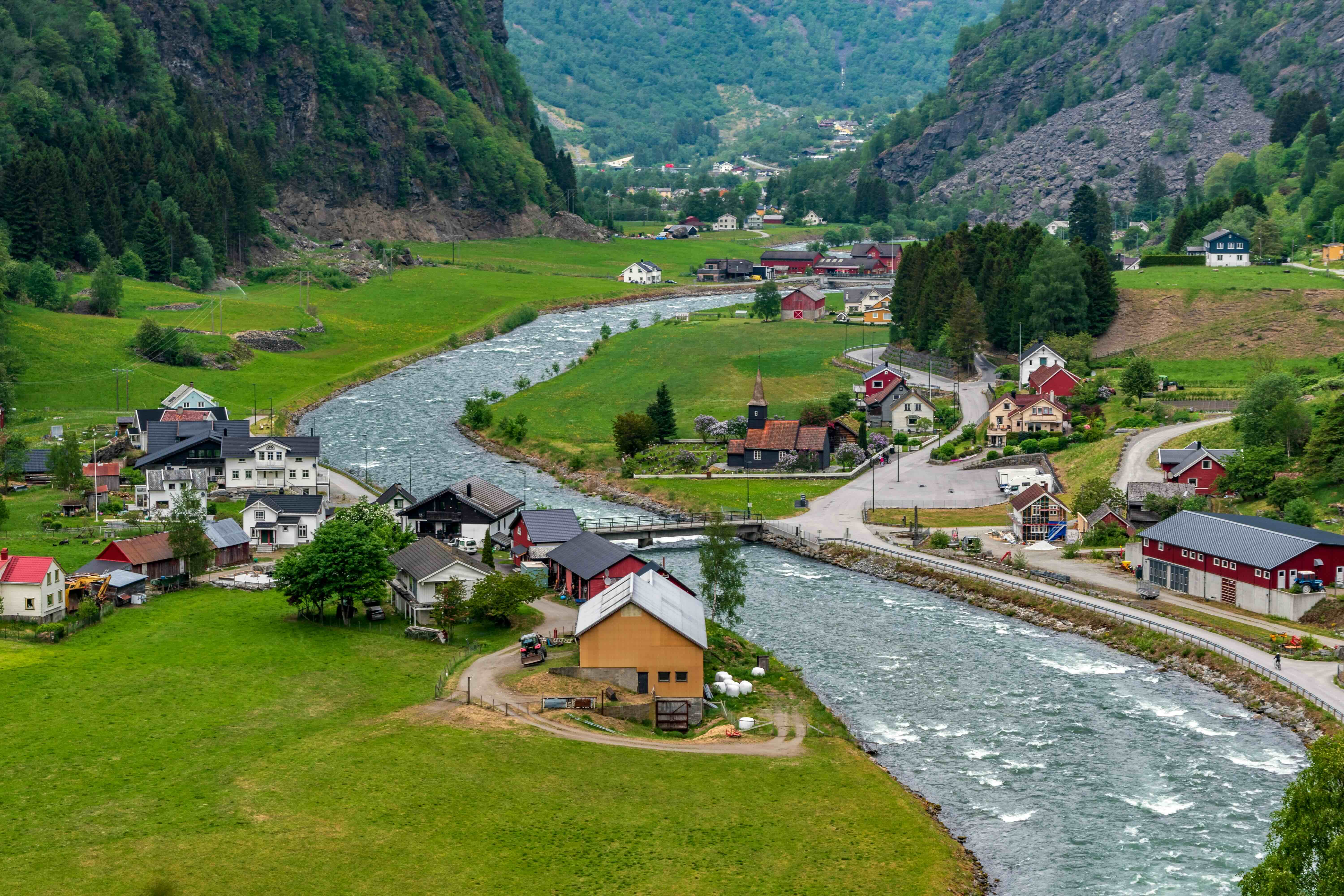 Flåm Railway train descending through waterfalls and mountains in the Norwegian fjords